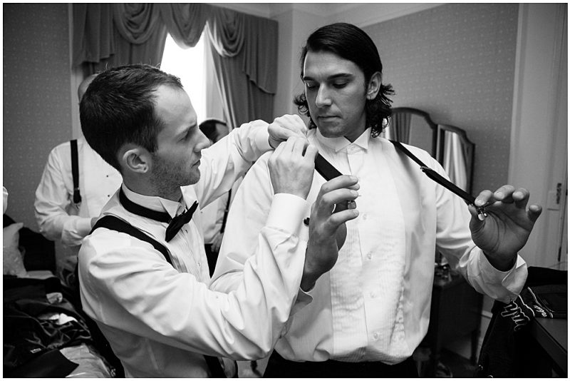 The groom helping his guys get dressed