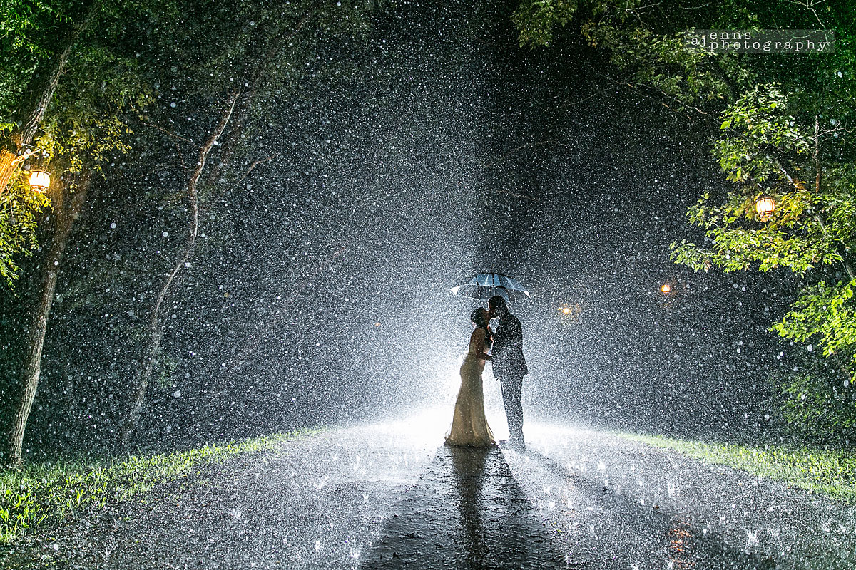 The couple hiding under their umbrella in a massive rain storm