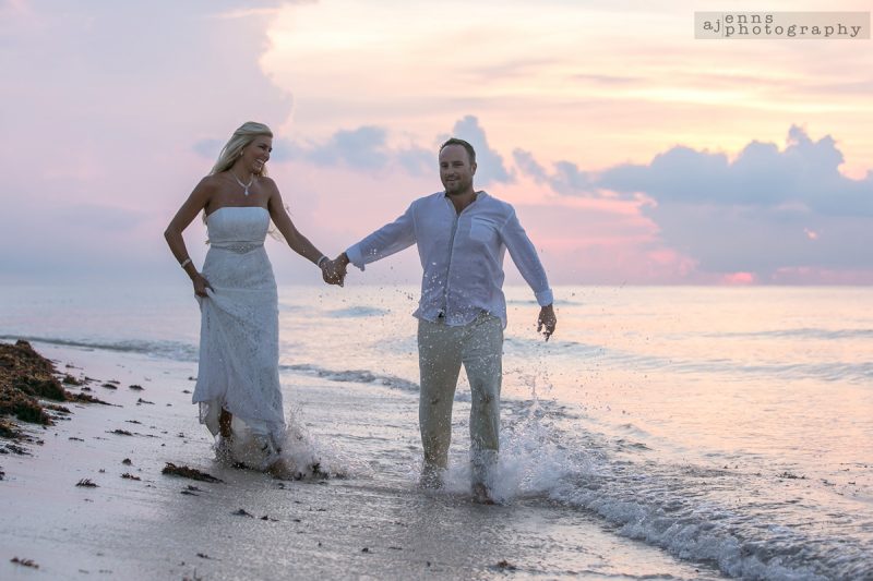 The couple holding hands running shoreside