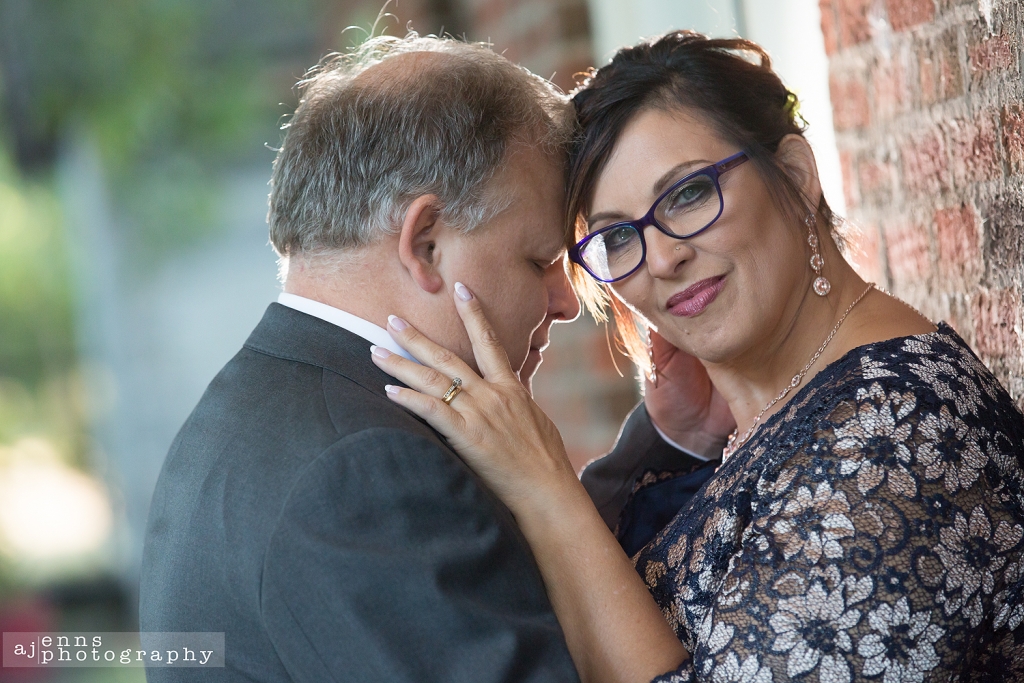 The groom leaning into his bride with her looking at the camera