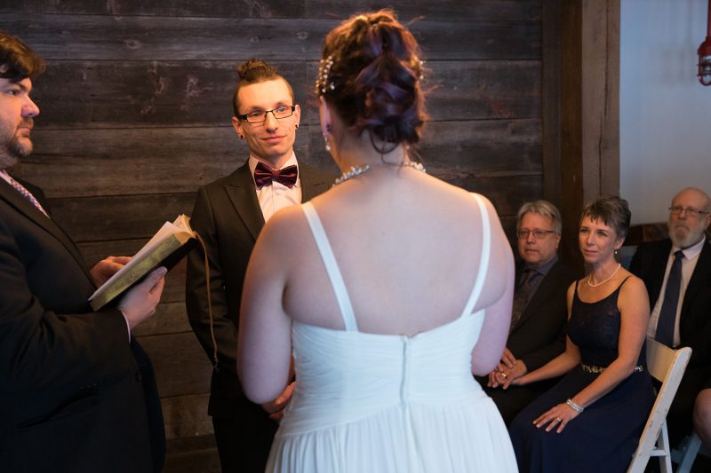 The groom admiring his bride while she recites her vows