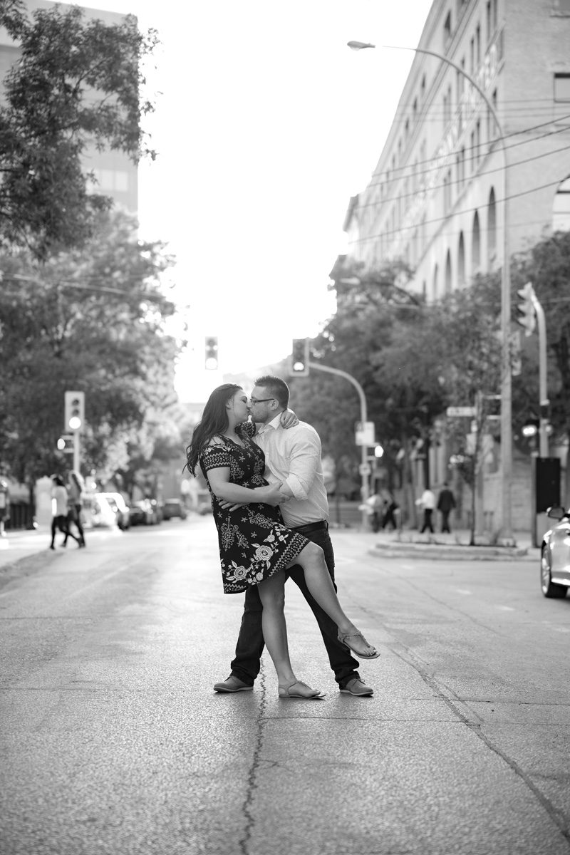 The couple kissing while dipping in the middle of a street downtown Exchange