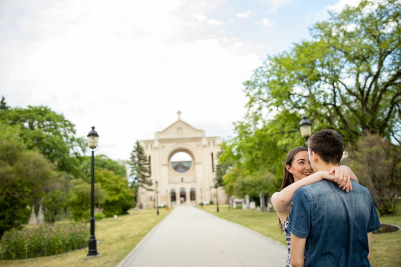 The couple cuddling with the St.Boniface ruins in the background