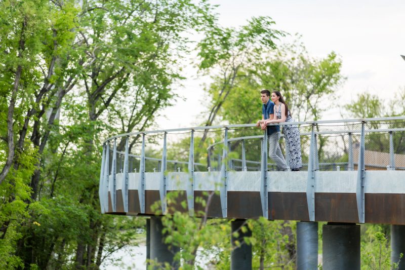 The couple leaning against the railing on the foot bridge in St. Boniface