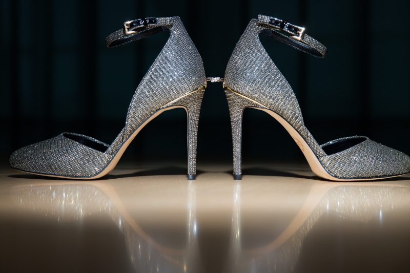 The engagement ring delicately balancing between the brides high heel shoes