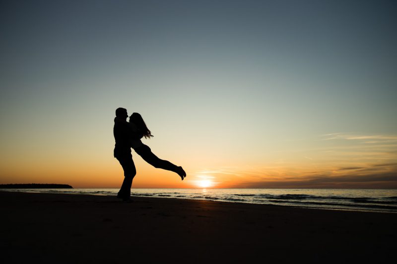 Brendan holding Arlita and spinning her on the beach at sunset