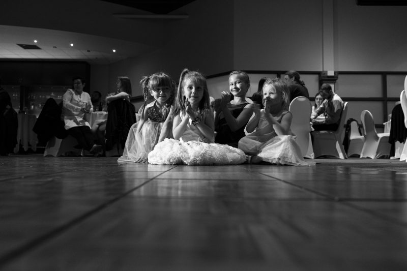 4 young girls sit on the dance floor while listening to speeches