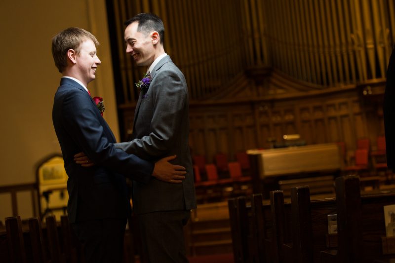 Brandon and Nathan hugging in front of the organ at Westminster Church