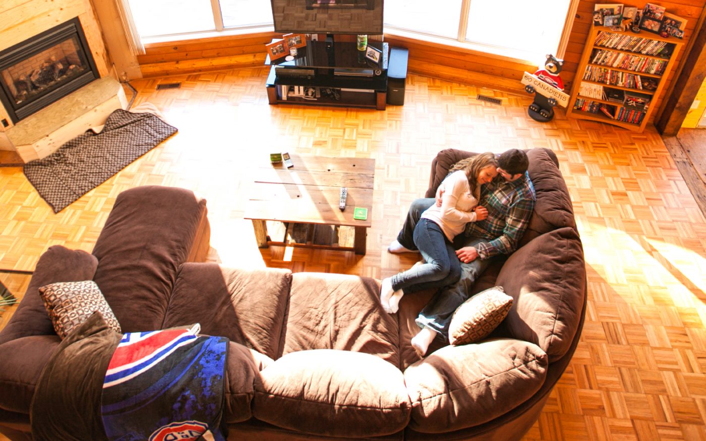 Leslie and Clayton cuddle on their couch in their cabin