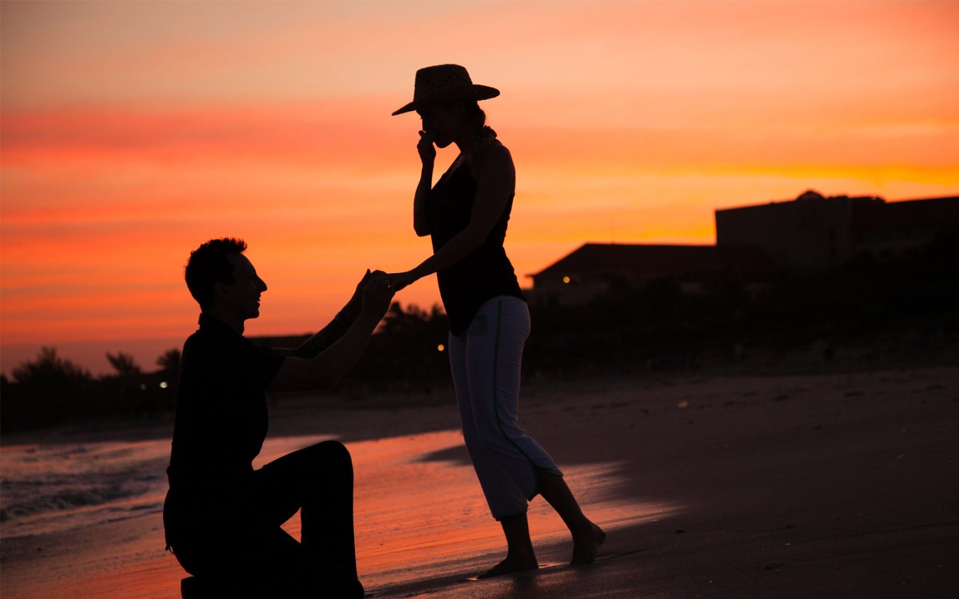 Steve proposing to Erin on one knee on the beach in Cuba