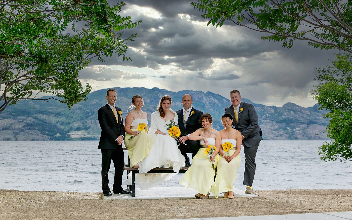 Bianca and Scott and their wedding party pose in front of Okanagan Lake