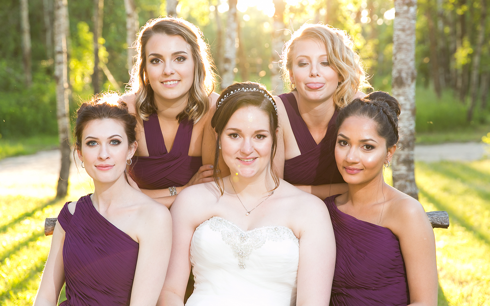 The bride and her bridesmaids with one sticking out her tongue