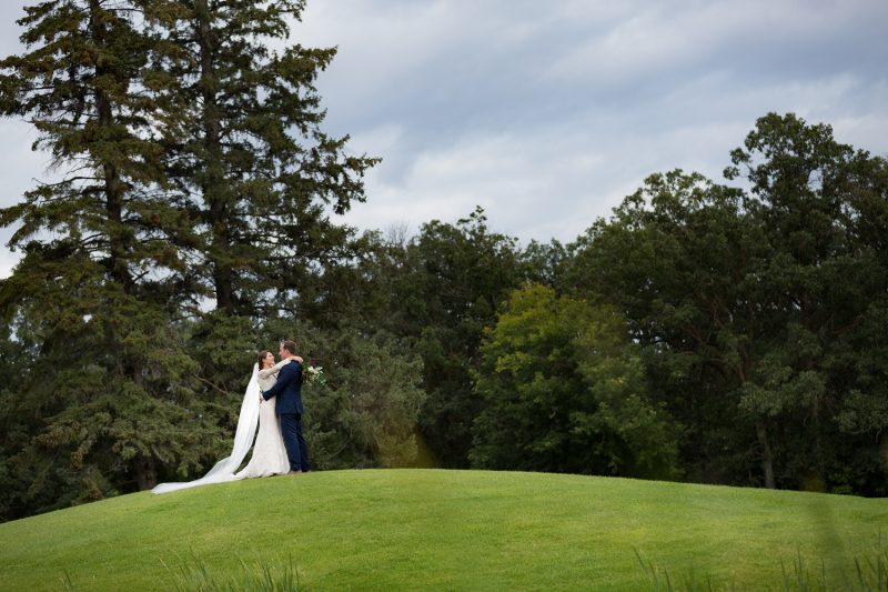 The couple embracing each other a ways across the golf course