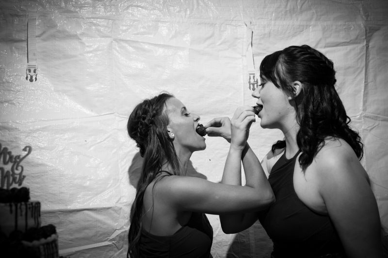 The bridesmaids wrapping their arms while feeding themselves chocolate covered strawberries