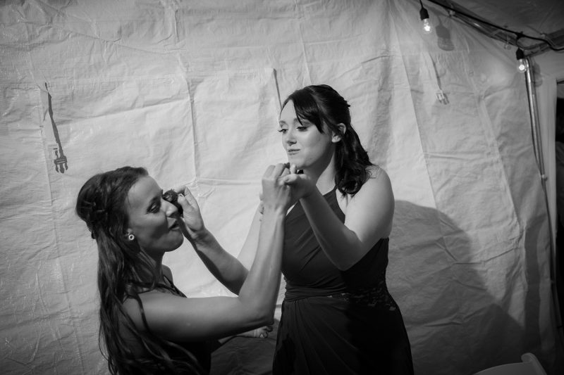 One bridesmaids smashing her chocolate covered strawberry into the eye of the other bridesmaid