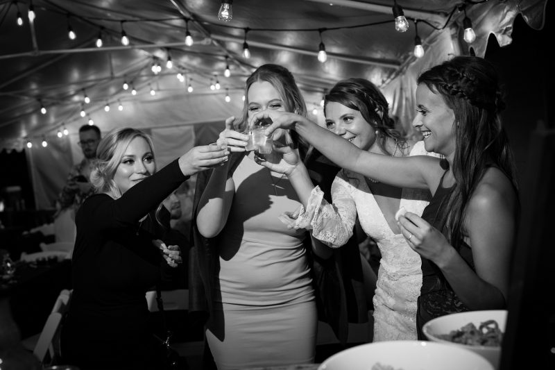 The women of the bridal party and the sisters doing cheersing