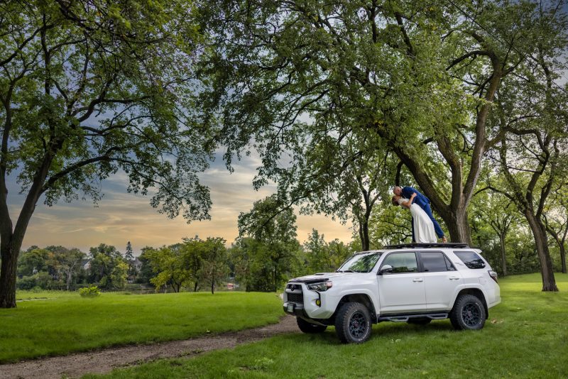 The couple dipping a kiss on top of a Toyota 4 Runner TRD Pro