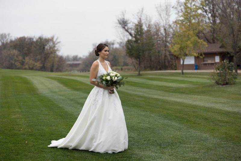 Jasmine walking down the isle at the outside wedding venue at Bridges Golf Course