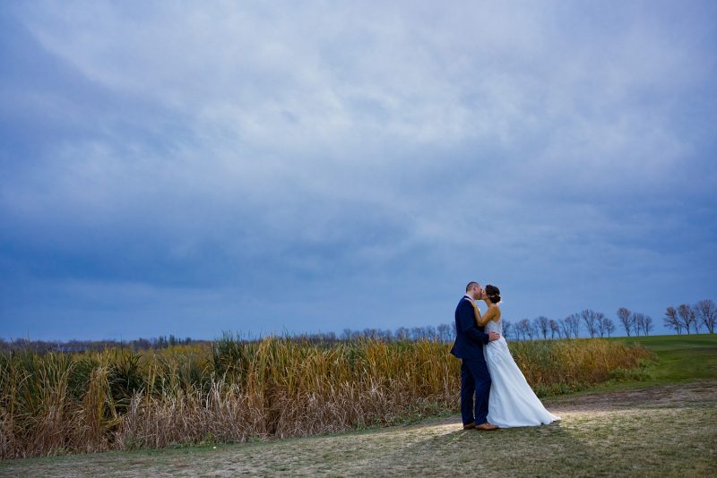 The couple kissing beside a pond at Bridges Golf Course