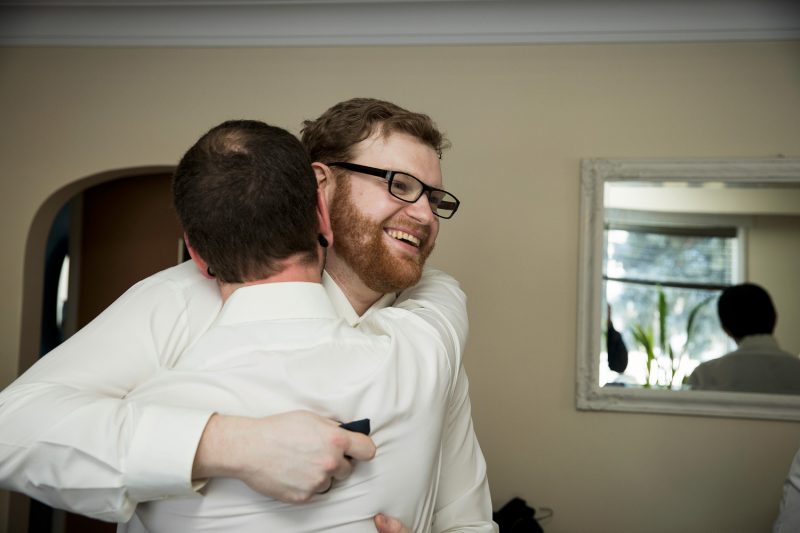 Peter hugging the best man while getting ready