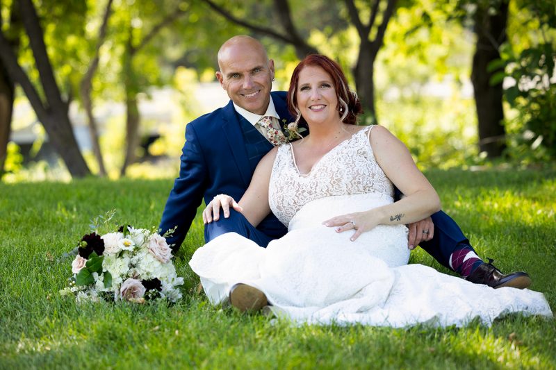 The couple sitting on the grass under some massive oak trees