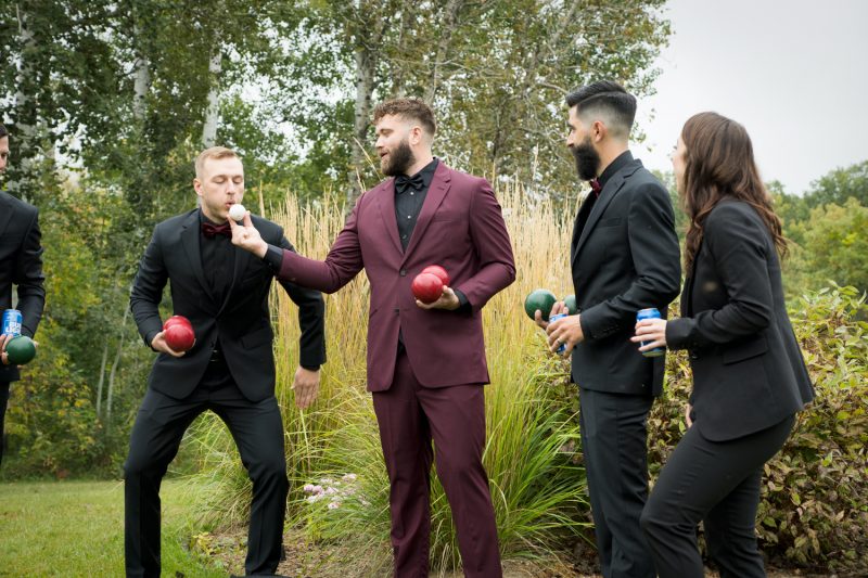 The groom holding a botchie ball for the best man to blow good luck on it