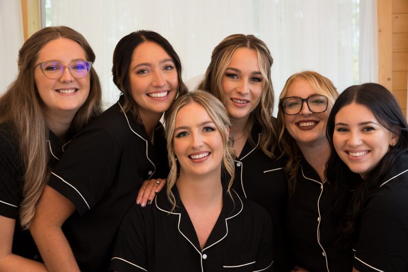 Karlie and her bridesmaids all cuddling for a portrait in a white curtained room