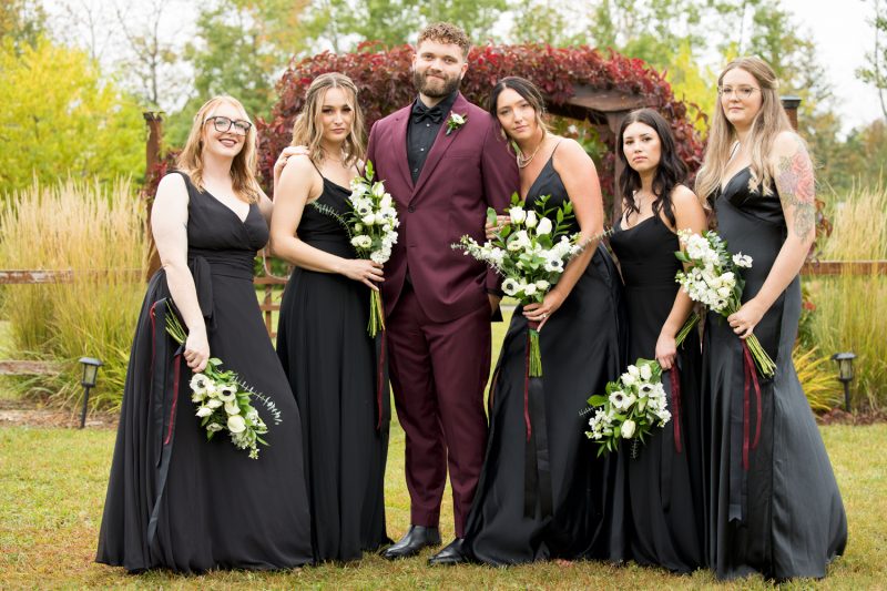 The groom posing with the bridesmaids