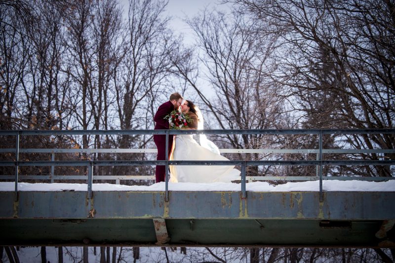 The couple kissing while standing on the bridge in -30 degrees weather