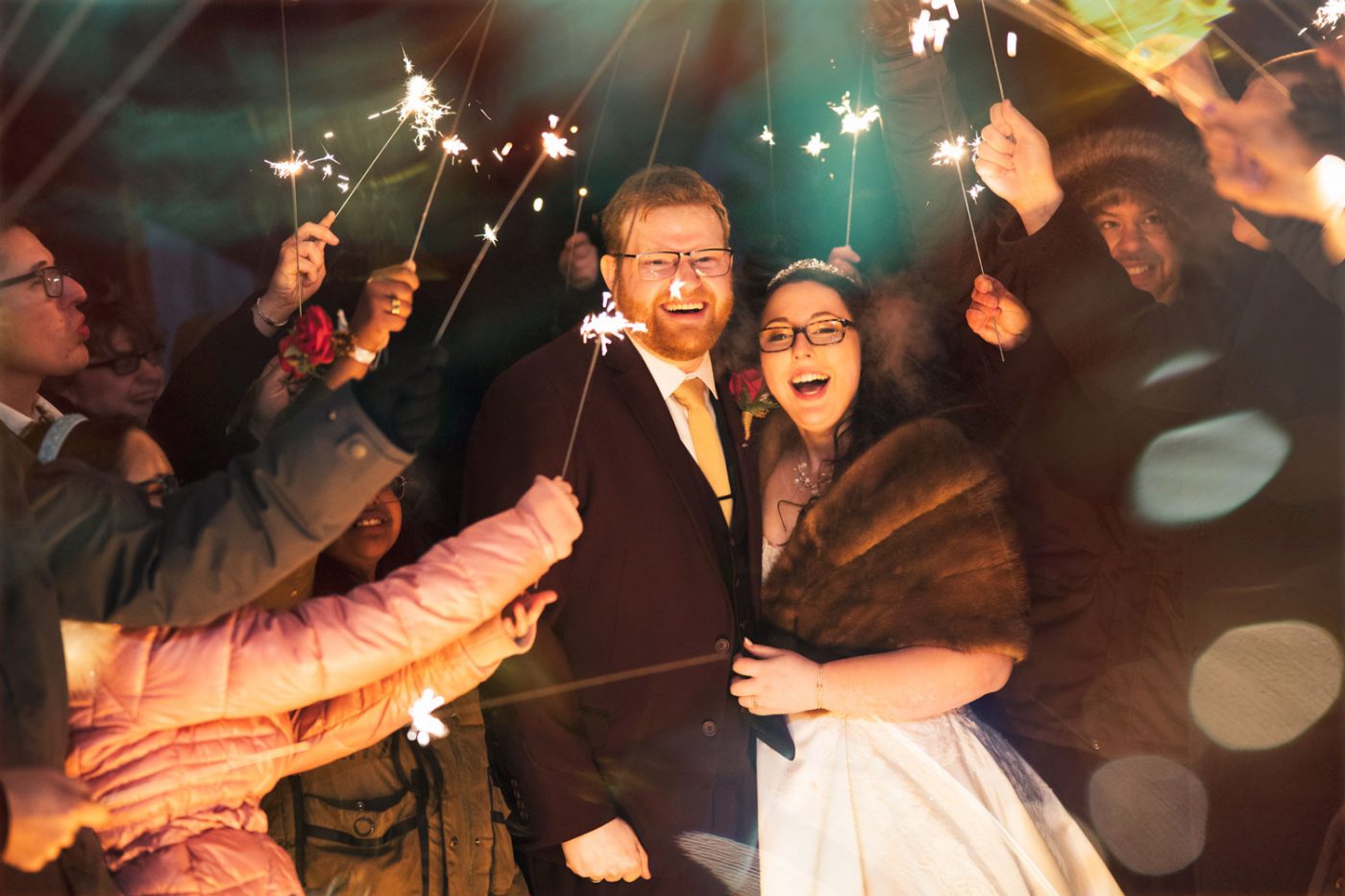 The couple surrounded by sparklers in the middle of winter