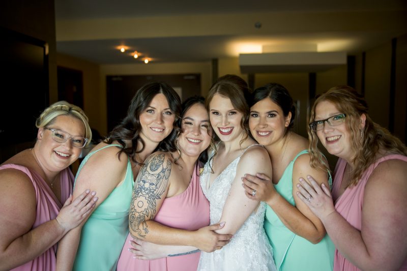 The bride and her bridesmaids all hugging