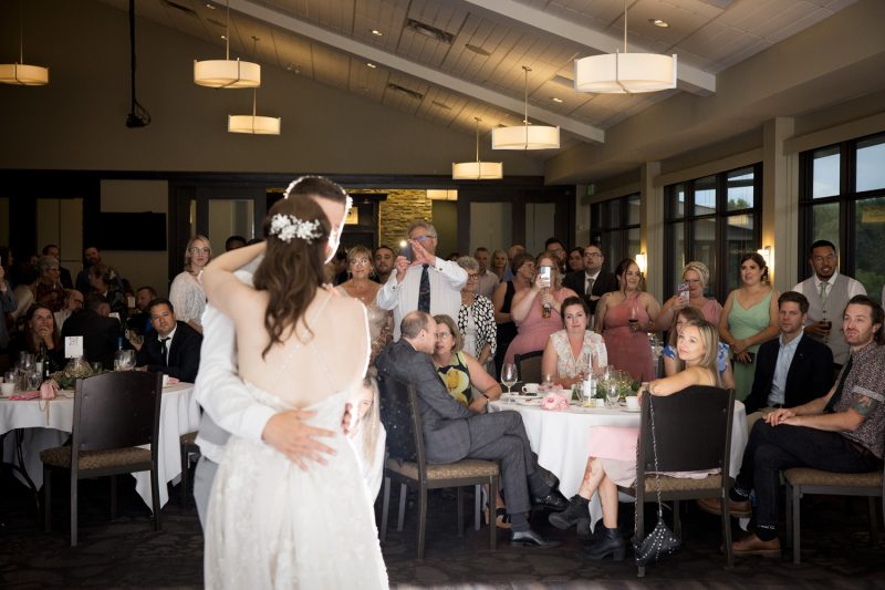 Image of the all the guests watching and photographing the couple during their first dane