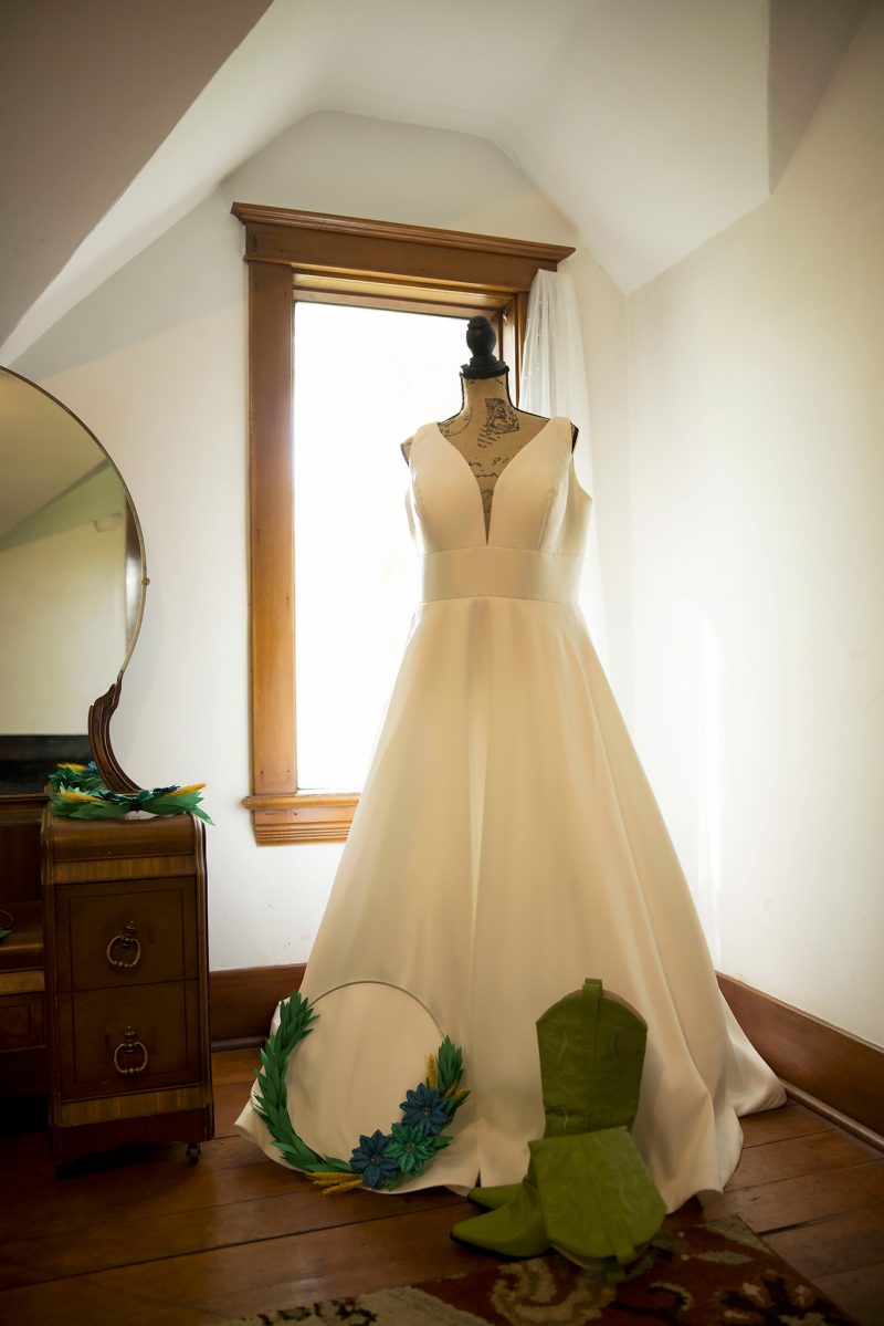 Nicky's wedding dress with her green cowboy boots in front
