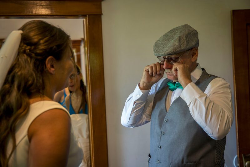 Father of the bride wipes away tears after seeing his daughter for the first time in her dress
