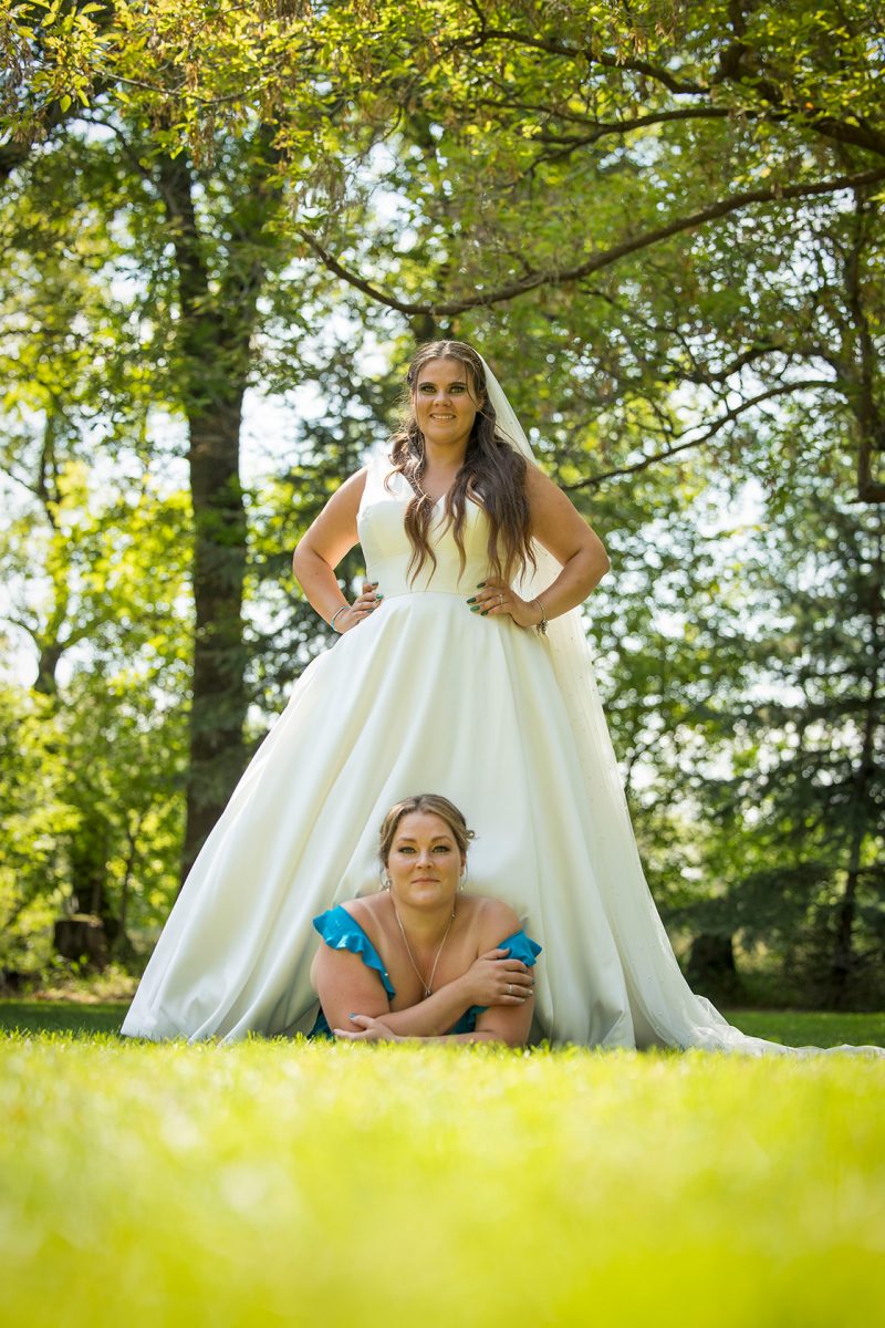 A bridesmaid re-enacts a shot where the the bride is standing over her while both facing the camera