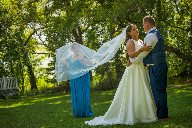 A bridesmaid pretends to be trapped under the veil