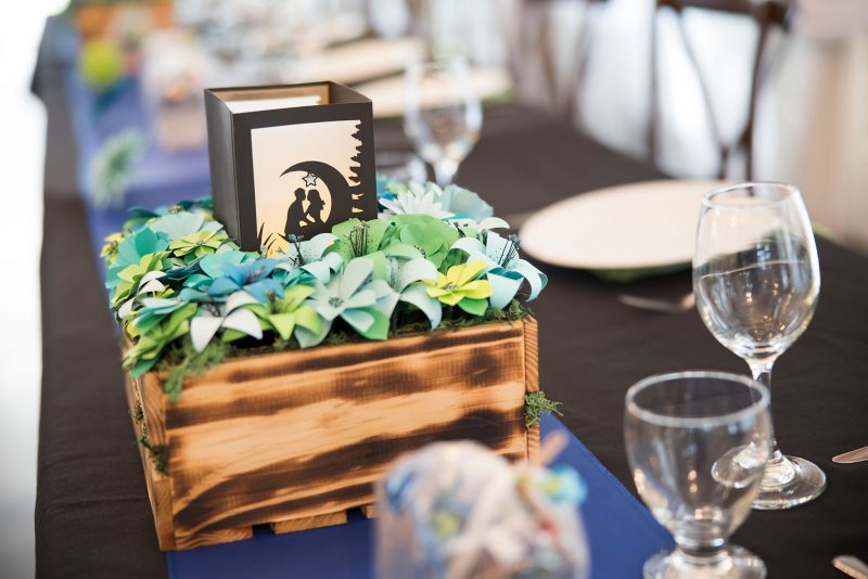 The handmade centre pieces made out of burnt wood and paper flowers